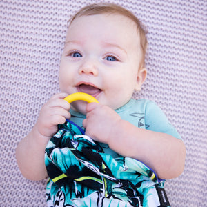 Baby cuddling Kauai One green palm print lovey with navy blue print on reverse side in silky soft bamboo jersey, best for baby teething soothing