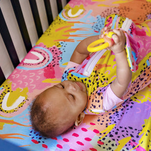 Baby with MiliMili x Pronoun by Jesse Tyler Ferguson Modern Rainbow Lovey, bamboo lovey, baby lovey, bamboo sleep sack, safe sleep sack, bamboo crib sheet, best crib sheet