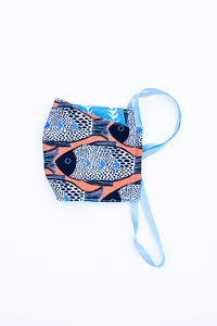 orange blue and black fish print cloth face mask with blue and white striped backing and blue straps.