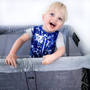 Toddler wearing MiliMili Playa Blue tie dye sleep sack in pack and play with MiliMili travel sheet. Made in the USA from bamboo jersey. Best sleep sacks for toddlers. safe bamboo sleep sack, safe sleep sack